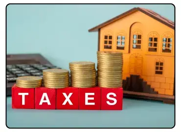 Stacked coins and house model with the word TAXES representing property tax and financial planning